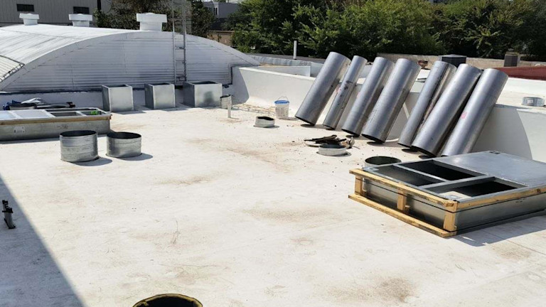 A roof with metal pipes on it