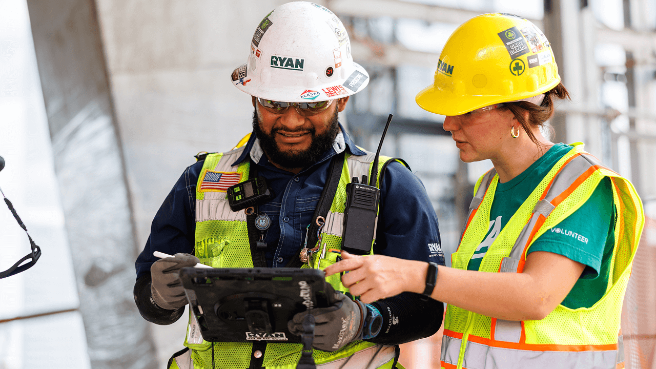 Two contractors using an iPad on a construction site