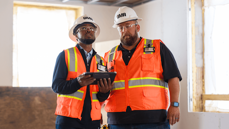 Two construction workers supervising a site